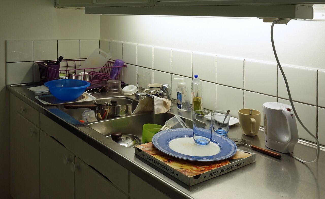 Cluttered kitchen sink before cleaning